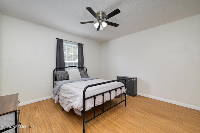 bedroom featuring a textured ceiling, light hardwood / wood-style floors, and ceiling fan