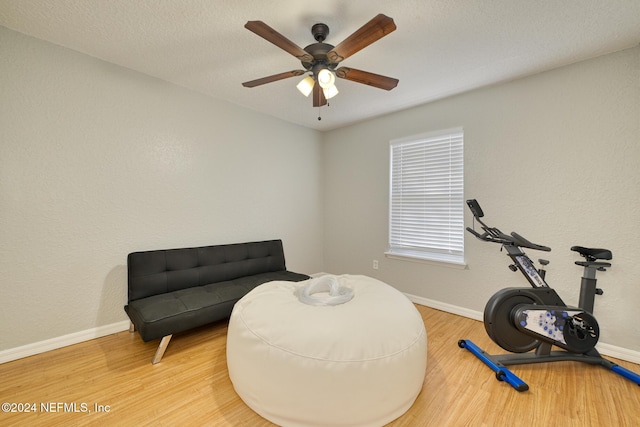 living area with hardwood / wood-style floors and ceiling fan