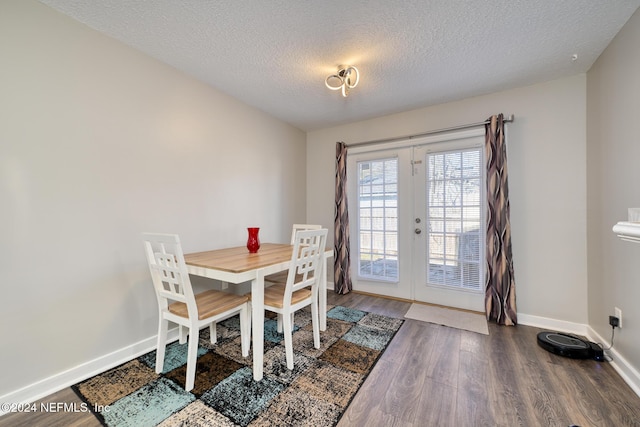 dining space featuring french doors, a textured ceiling, and hardwood / wood-style flooring