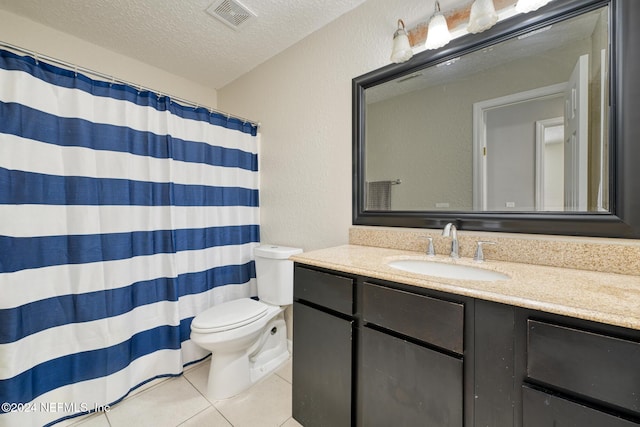 bathroom with vanity, tile patterned flooring, toilet, a textured ceiling, and walk in shower