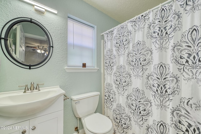 bathroom featuring curtained shower, vanity, a textured ceiling, and toilet