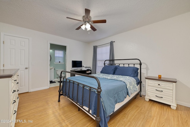 bedroom featuring ceiling fan, ensuite bathroom, a textured ceiling, and light hardwood / wood-style floors