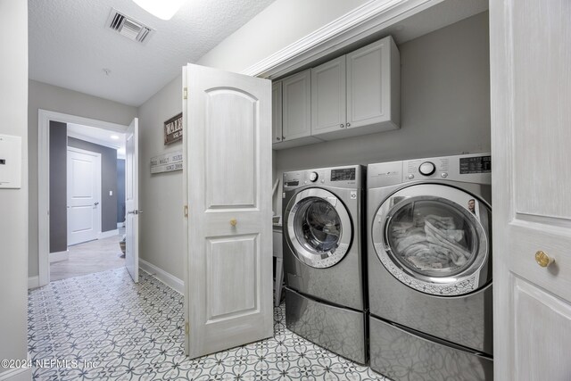 1431 Riverplace Blvd Unit 2105, Jacksonville, FL 32207 - clothes washing area featuring visible vents, baseboards, a textured ceiling, and washing machine and clothes dryer