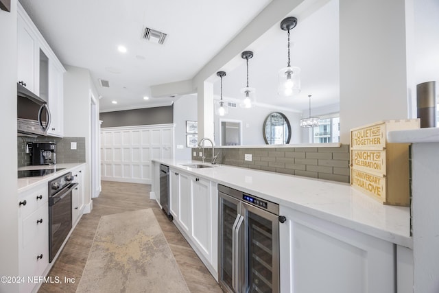 1431 Riverplace Blvd Unit 2105, Jacksonville, FL 32207 - kitchen featuring visible vents, black appliances, beverage cooler, white cabinetry, and a sink