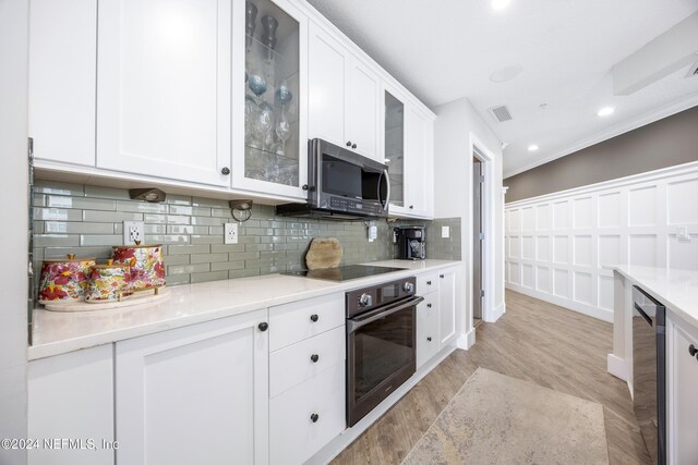 1431 Riverplace Blvd Unit 2105, Jacksonville, FL 32207 - kitchen with tasteful backsplash, visible vents, white cabinets, and black appliances