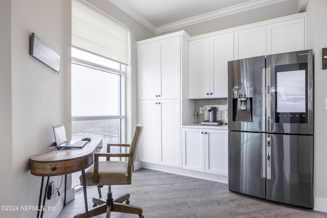 1431 Riverplace Blvd Unit 2105, Jacksonville, FL 32207 - kitchen featuring light wood finished floors, backsplash, crown molding, stainless steel fridge with ice dispenser, and white cabinetry