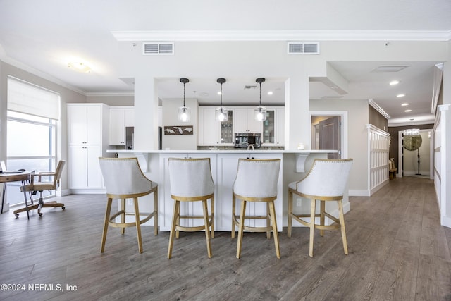 1431 Riverplace Blvd Unit 2105, Jacksonville, FL 32207 - kitchen with visible vents, a breakfast bar area, stainless steel microwave, and crown molding