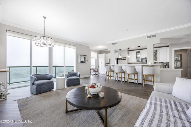 1431 Riverplace Blvd Unit 2105, Jacksonville, FL 32207 - living room featuring visible vents, a notable chandelier, ornamental molding, wood finished floors, and baseboards