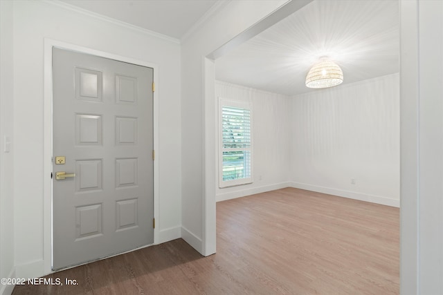 foyer featuring wood-type flooring and ornamental molding