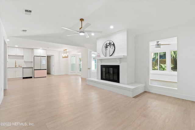 unfurnished living room featuring light hardwood / wood-style floors, a brick fireplace, ceiling fan, and lofted ceiling