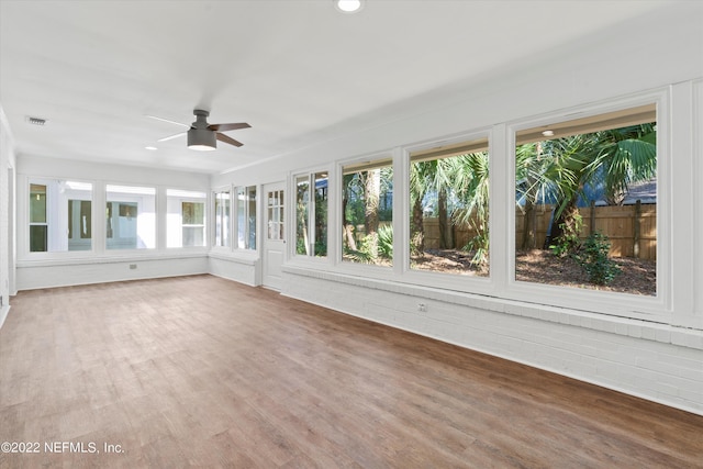 unfurnished sunroom with ceiling fan