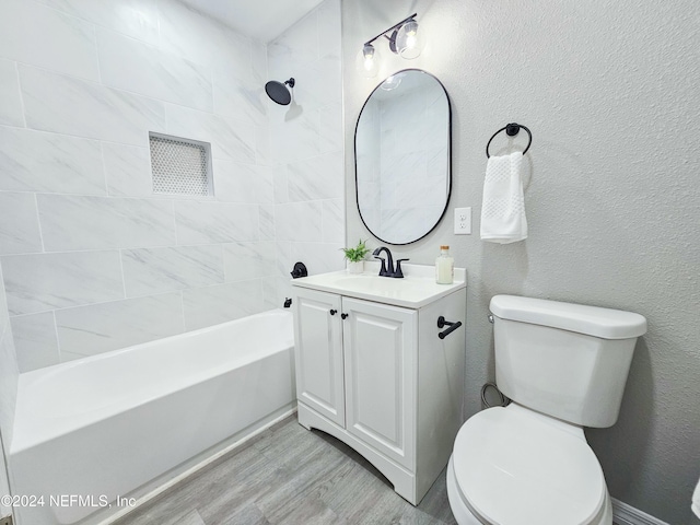 full bathroom featuring hardwood / wood-style floors, vanity, toilet, and tiled shower / bath combo