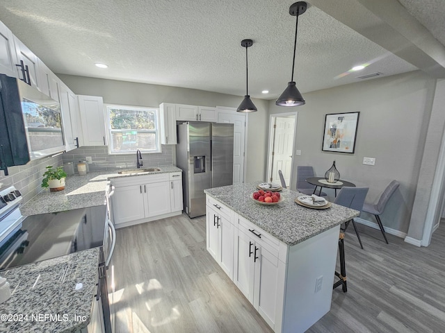 kitchen featuring white cabinets, a center island, and appliances with stainless steel finishes