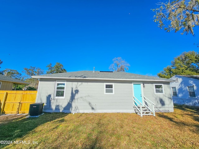 rear view of house with a yard and cooling unit