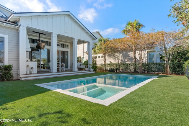 view of pool with a yard and an in ground hot tub