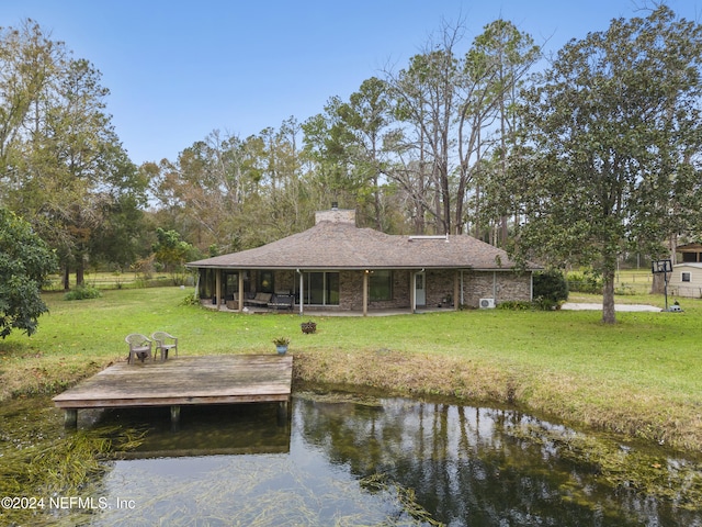 view of dock featuring a lawn and a water view