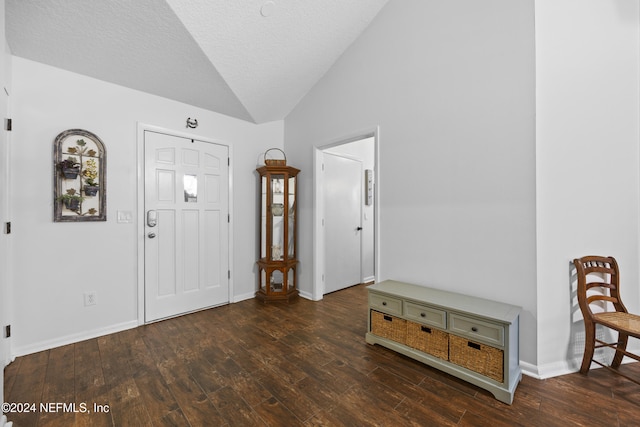 foyer entrance with a textured ceiling, dark hardwood / wood-style flooring, and lofted ceiling