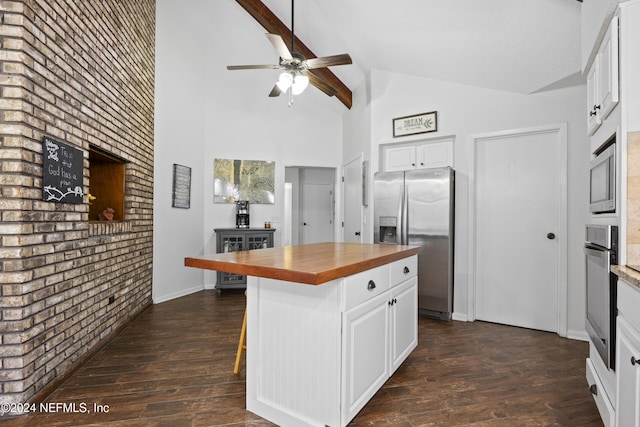 kitchen with a center island, butcher block counters, white cabinetry, and stainless steel appliances