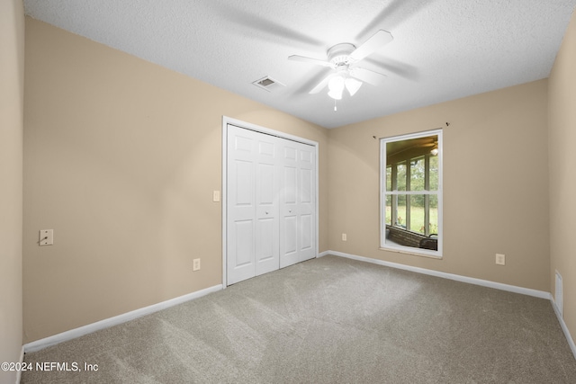 unfurnished bedroom with ceiling fan, a closet, carpet, and a textured ceiling