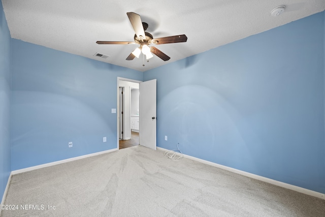 carpeted spare room featuring a textured ceiling and ceiling fan