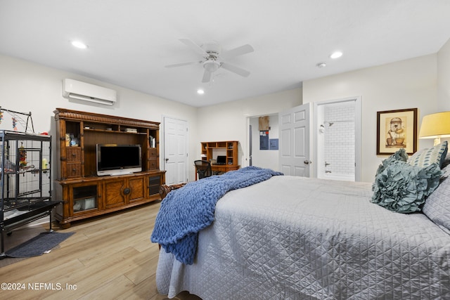 bedroom with ceiling fan, light hardwood / wood-style floors, ensuite bathroom, and a wall mounted AC