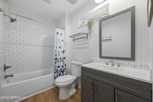 full bathroom featuring wood-type flooring, vanity, toilet, and shower / bathtub combination with curtain