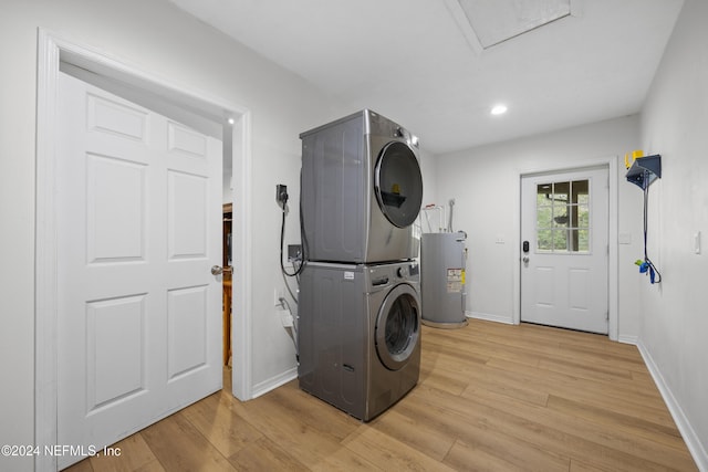 washroom featuring light wood-type flooring, electric water heater, and stacked washer / drying machine