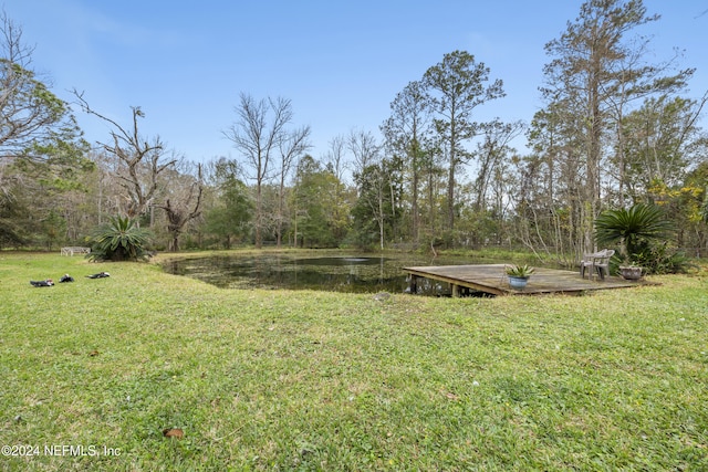 view of yard with a deck with water view