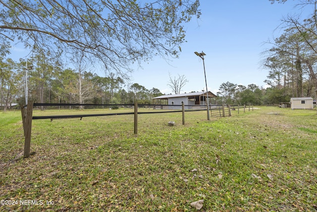 view of yard featuring a rural view and a shed