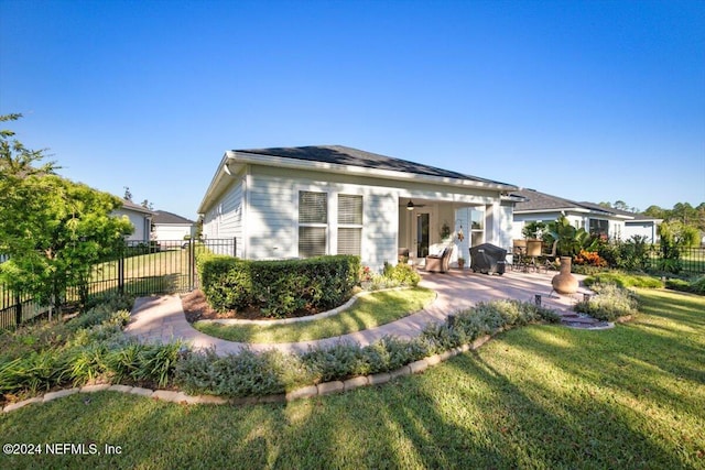 rear view of house featuring a lawn, ceiling fan, and a patio