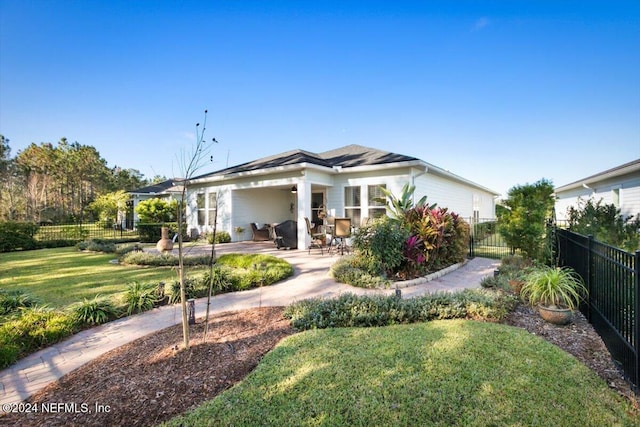 rear view of property with a patio area and a yard