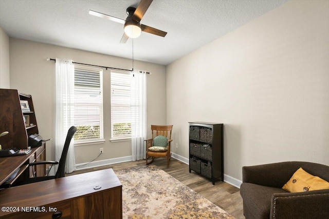 office area featuring ceiling fan, light hardwood / wood-style floors, and a textured ceiling