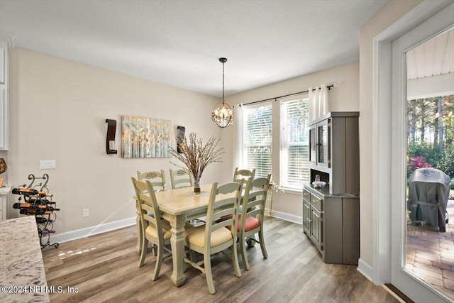 dining space with wood-type flooring and an inviting chandelier