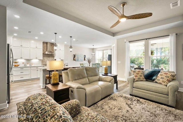 living room featuring ceiling fan and light hardwood / wood-style flooring