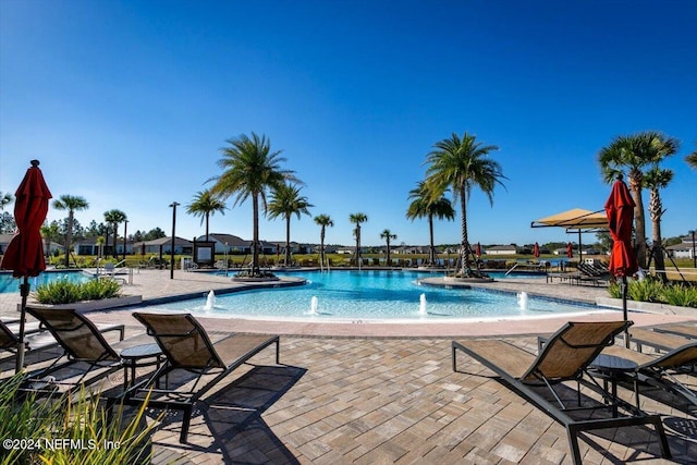 view of pool with pool water feature and a patio