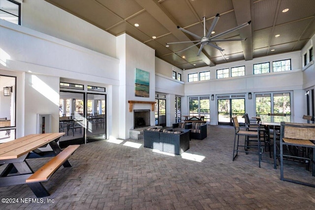 living room featuring ceiling fan and a high ceiling