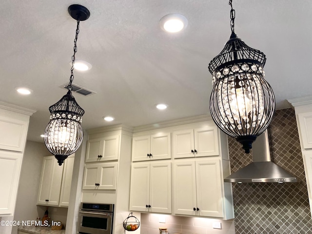 interior details featuring ornamental molding, decorative light fixtures, a notable chandelier, and stainless steel oven