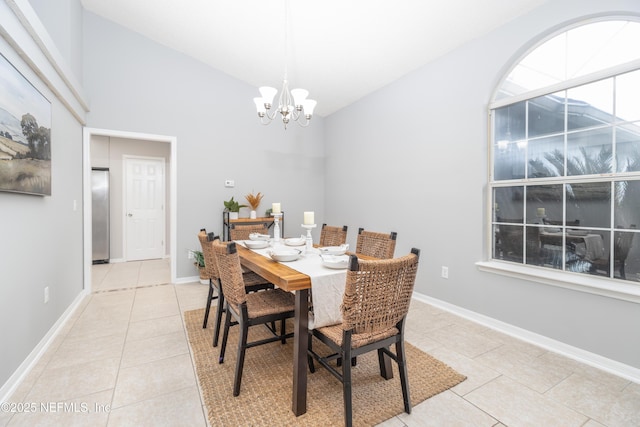 dining space featuring a notable chandelier, light tile patterned floors, and lofted ceiling