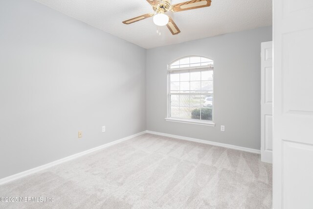 empty room with a textured ceiling, light colored carpet, and ceiling fan