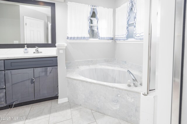 bathroom featuring vanity, tile patterned floors, and a bathtub