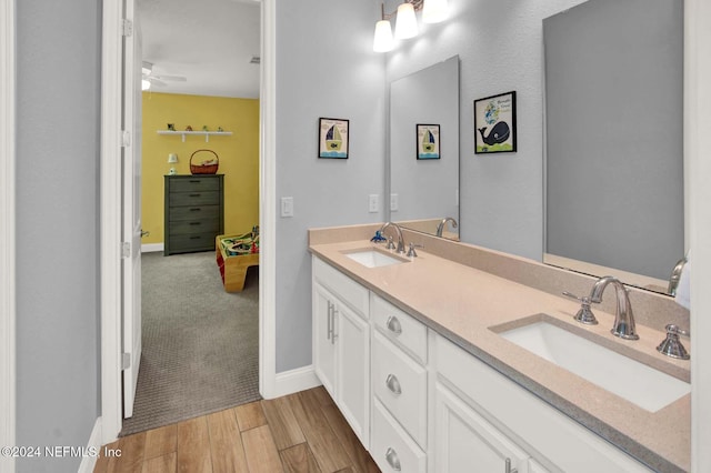 bathroom with hardwood / wood-style flooring, ceiling fan, and vanity