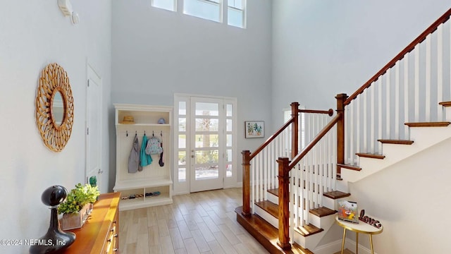 entrance foyer with light hardwood / wood-style flooring and a towering ceiling