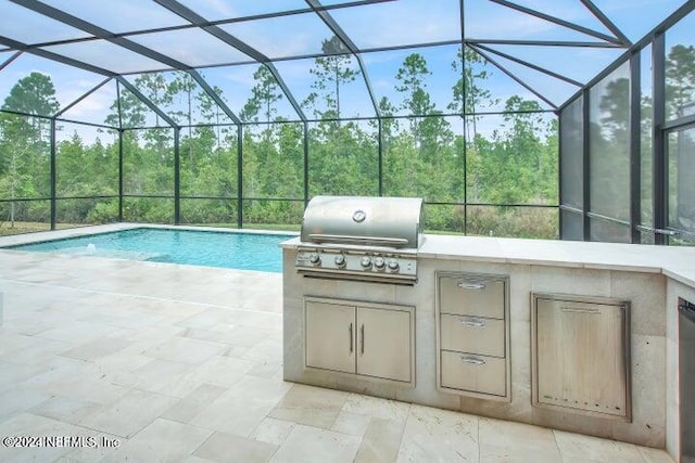 view of patio with a lanai, area for grilling, and an outdoor kitchen