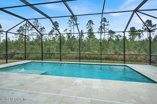 view of pool with a patio area and a lanai