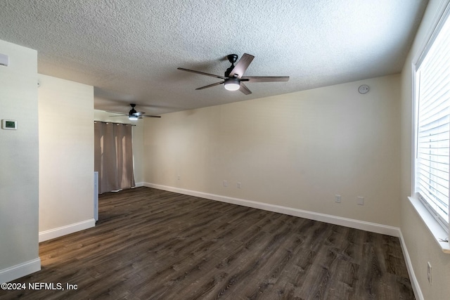 spare room with a textured ceiling and dark hardwood / wood-style flooring