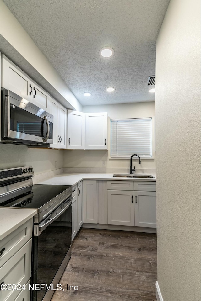 kitchen featuring sink, white cabinetry, stainless steel appliances, and dark wood-type flooring