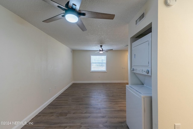 laundry room featuring a textured ceiling, dark hardwood / wood-style floors, and stacked washer / dryer