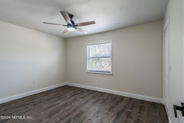 spare room with dark hardwood / wood-style flooring and a textured ceiling