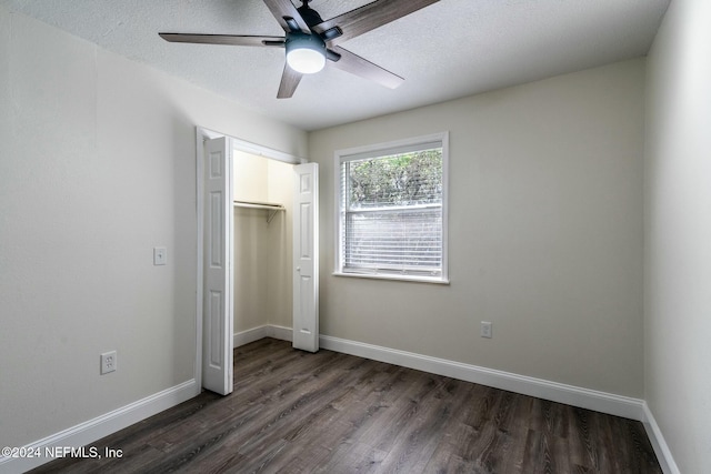 unfurnished bedroom with a textured ceiling, ceiling fan, dark wood-type flooring, and a closet