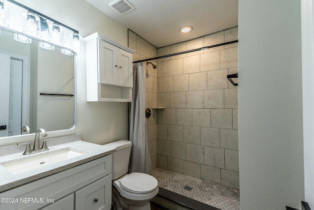 bathroom featuring a shower with shower curtain, a textured ceiling, vanity, and toilet